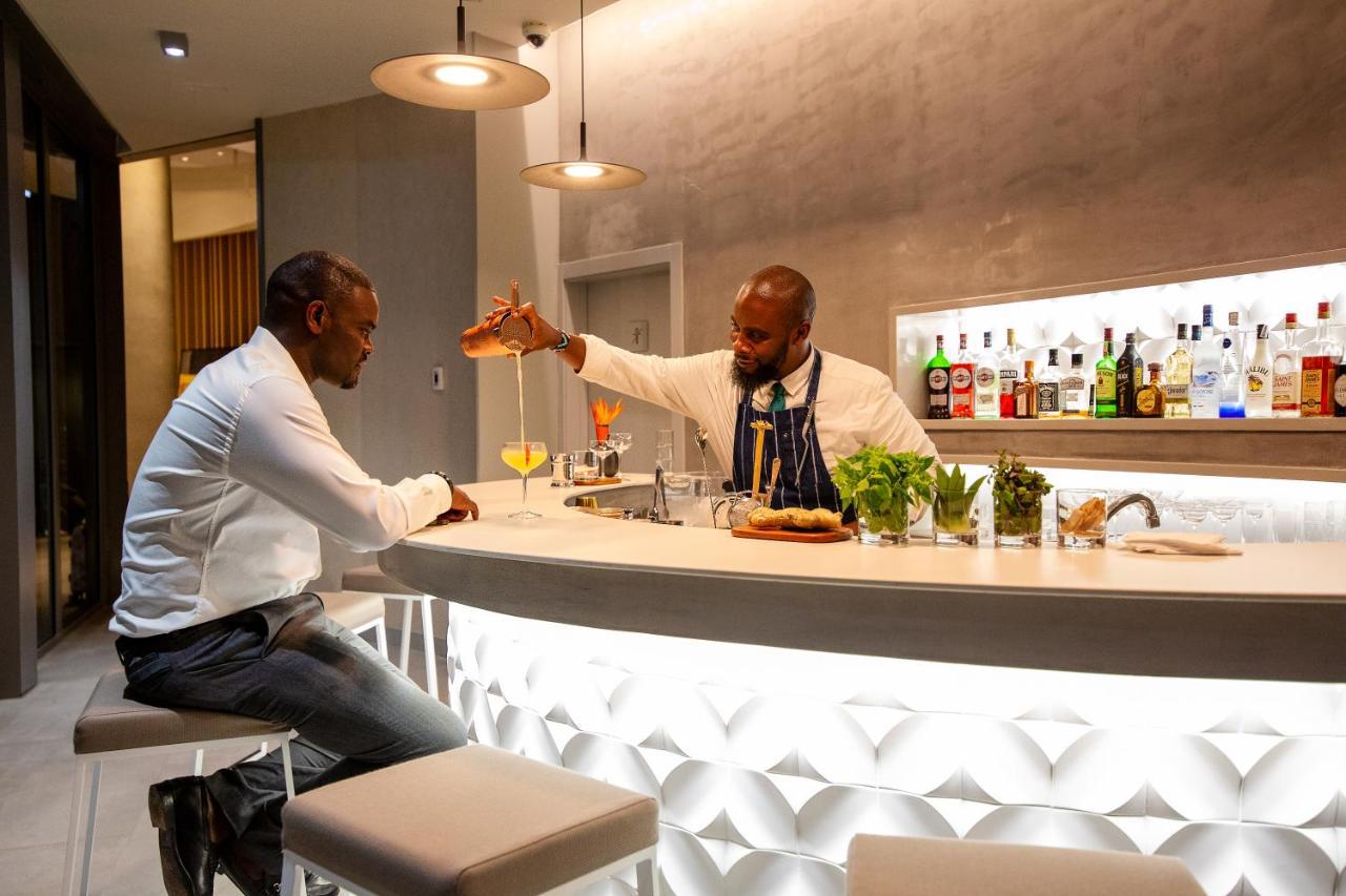 Noom Hotel Abidjan Plateau Exterior photo A bartender at work